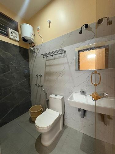 a bathroom with a toilet and a sink at Thilo Guest House Auroville in Auroville