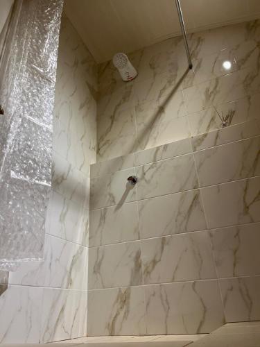 a bathroom with a shower with white marble tiles at Casa Prusia, tipica de pioneros europeos in Aristóbulo del Valle