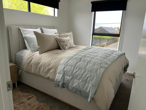 a bedroom with a bed with pillows and a window at The Park Premium 2 Bedroom Apartment in Christchurch