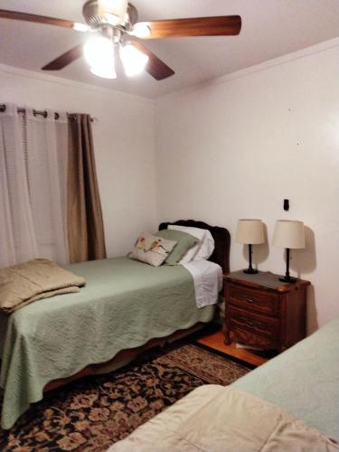 a bedroom with two beds and a ceiling fan at Casa Castillo 2 in La Puente