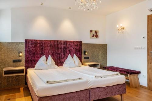 ein Schlafzimmer mit einem großen Bett mit einem lila Kopfteil in der Unterkunft Haus Rosengarten Apt D in Terlan