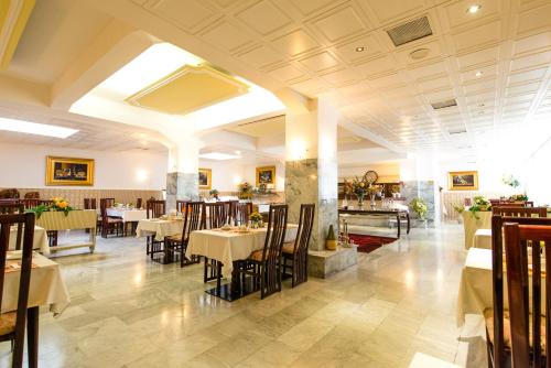 a restaurant with tables and chairs in a room at Ravel International in Offenbach