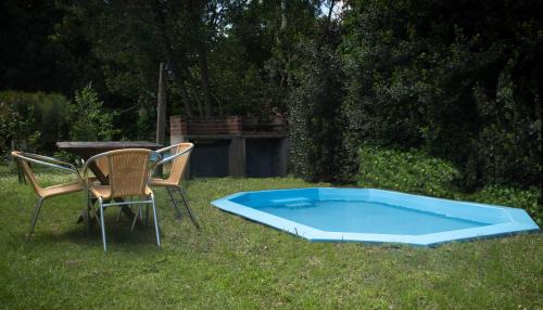 a table and two chairs sitting next to a blue pool at Casa Isabela in Santa Clara del Mar