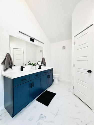 a bathroom with a blue sink and a mirror at Modern & Cozy house with pool in The Colony
