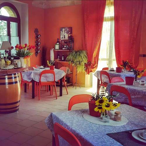 a restaurant with red walls and tables and chairs at Agriturismo Cascina Favorita in Alfiano Natta
