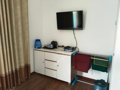 a room with a desk with a television on the wall at Guesthouse Sadamantra in Maniskaler