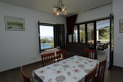 a dining room with a table and a view of the water at Family-friendly apartments with swimming pool Selca, Brac - 22810 in Selca