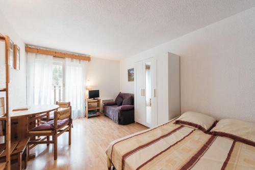 a bedroom with a bed and a table and a couch at Studio Barèges ski, rando, cure in Barèges