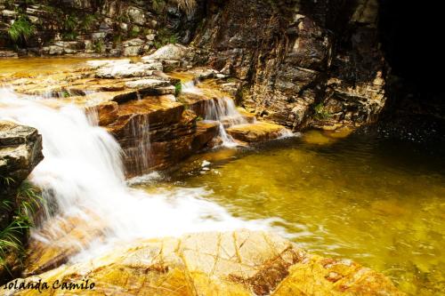 a stream of water rushing over rocks in a waterfall at Cachoeiras Pé da Serra in São João Batista do Glória
