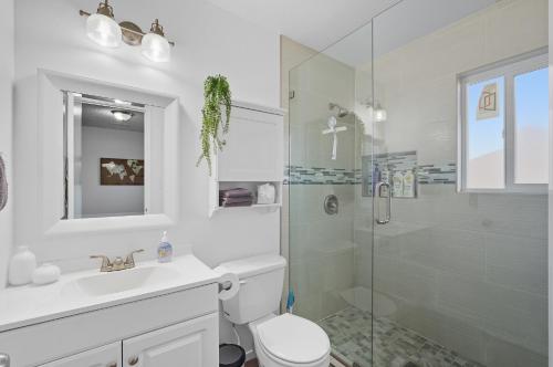 a bathroom with a shower and a toilet and a sink at The Cozy Rustic Sequoia Wi-Fi & 2 Garage in Tulare