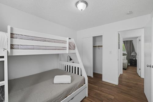 a bedroom with two bunk beds and a hallway at The Cozy Rustic Sequoia Wi-Fi & 2 Garage in Tulare