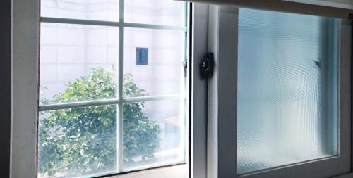 an open window with a view of a tree at Namsan Nest in Seoul