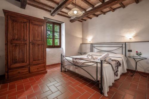 a bedroom with a bed and a wooden cabinet at Ginestra in Arcidosso