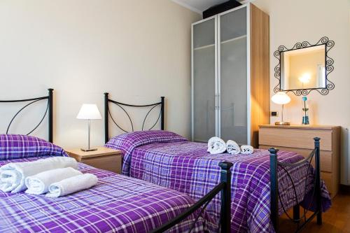 two beds in a room with purple sheets and towels at Raggio di Sole in Torre del Lago Puccini