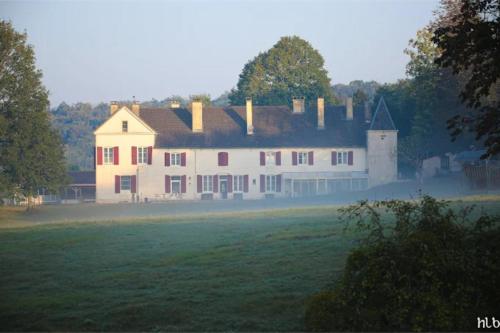 a large white house in the middle of a field at Domaine du Val Bruant in Arc-en-Barrois