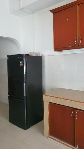 a kitchen with a black refrigerator in a room at Aristar D'Permatang Homestay 4 mu5lim in Bandar  Pusat Jengka