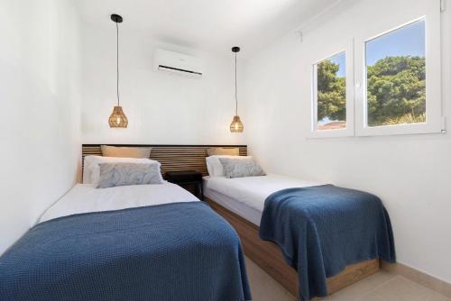 two beds in a room with two windows at La Lajita Beach Estudio in La Lajita