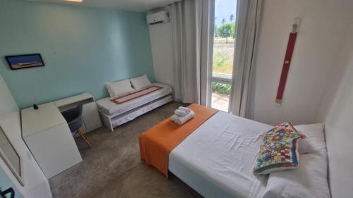 a small bedroom with a bed and a window at VIVA! 4 Casa em condomínio entre Carneiros e Maragogi in São José da Coroa Grande