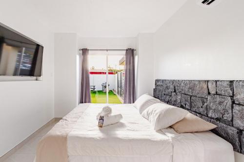 een wit bed met een handdoek erop in een kamer bij Arubini - aruba in Palm-Eagle Beach