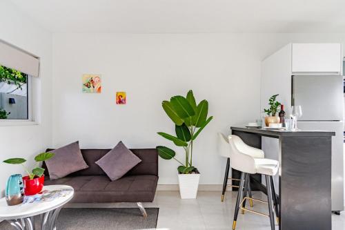 een woonkamer met een bank en een tafel bij Arubini - aruba in Palm-Eagle Beach