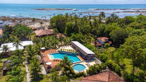 an aerial view of a resort with a pool and the ocean at Village Paraíso Tropical in Morro de São Paulo