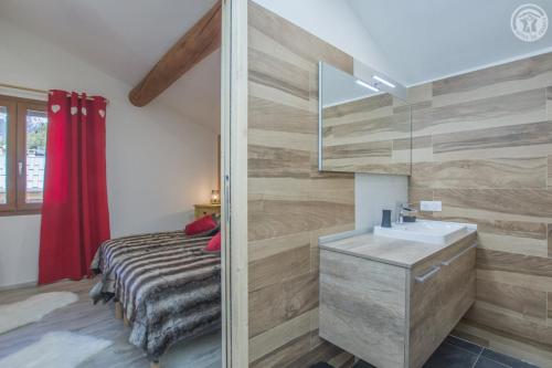 a bedroom with a bed and a sink and a mirror at Gîte Les Mélèzes in Termignon