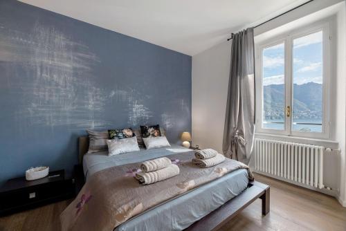 Un dormitorio con una cama con una pared azul. en Suite panoramica in Guest House, en Moltrasio