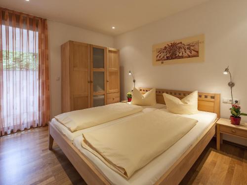 a bedroom with a large bed with white sheets at Ferienwohnung Kobl in Immenstaad am Bodensee