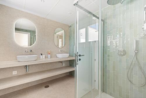 アルガロボにあるVilla Clery Algarroboのバスルーム(洗面台2台、ガラス張りのシャワー付)