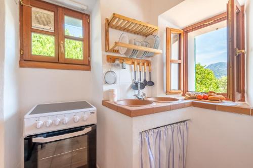 a kitchen with a sink and a stove and a window at Can Costurer in Sóller