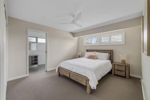 ein weißes Schlafzimmer mit einem Bett und einem Fenster in der Unterkunft Casa del Mar Phillip Island Ocean Views in Surf Beach