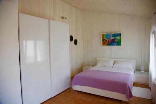 1 dormitorio con 1 cama con manta morada en Holiday Home Pineta, en Vinkuran