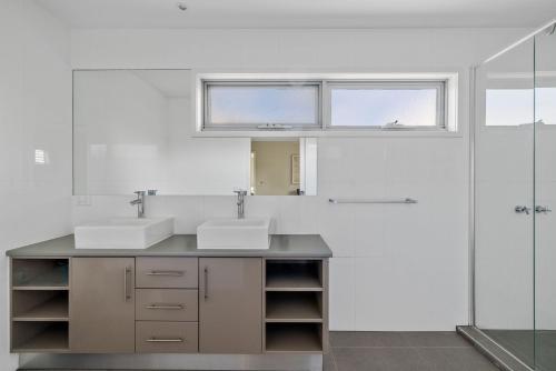 ein Badezimmer mit zwei Waschbecken und einer Dusche in der Unterkunft Casa del Mar Phillip Island Ocean Views in Surf Beach