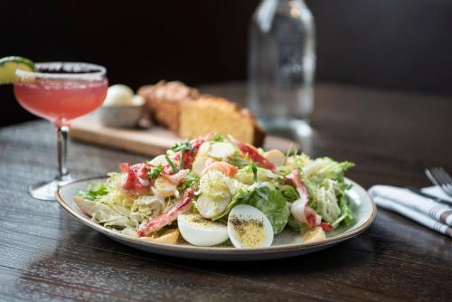 un plato de ensalada y huevos en una mesa con una bebida en McKinley Chalet Resort en McKinley Park