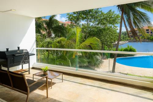 a living room with a piano and a view of a pool at High-End Waterfront Condo at Secrets Waters in Puerto Aventuras
