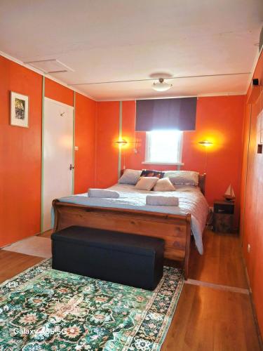 a bedroom with orange walls and a large bed at Lazy Shanty in American River