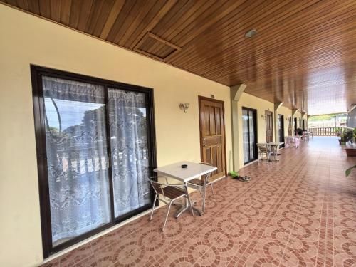 an empty hallway with a table and large windows at S&C Hotel Suites and Apartments in Koror