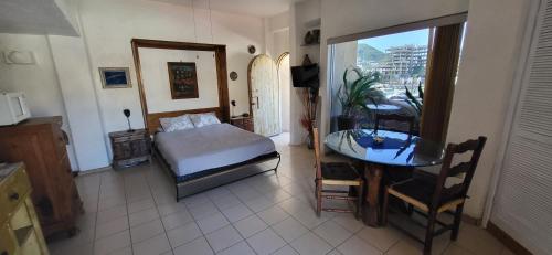 a bedroom with a bed and a desk and a table at Marina Cabo Plaza "Casa Pura Vida" 108A in Cabo San Lucas