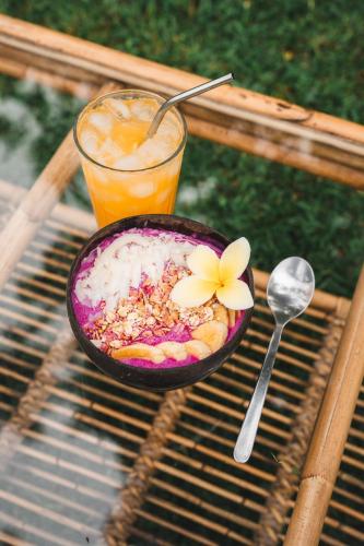 a bowl of food and a drink on a table at Batu Kayu Medewi in Medewi