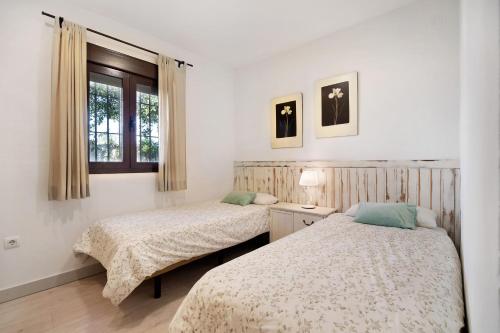 カディスにあるCasa Dos Maresのベッド2台と窓のある寝室