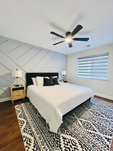 a bedroom with a white bed and a ceiling fan at Pickleball , Pool , Bkyd Oasis , Centrally Located in Frisco