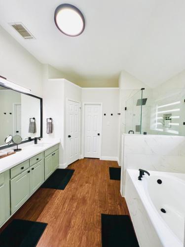 a bathroom with two sinks and a large mirror at Pickleball , Pool , Bkyd Oasis , Centrally Located in Frisco