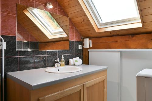a bathroom with a sink and a skylight at Chez Fred 201 - Parking Wifi in Saint-Pierre-dʼAlbigny