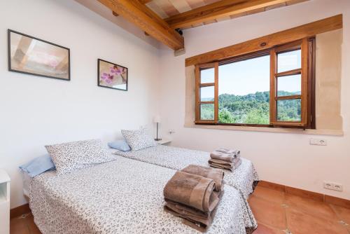a bedroom with two beds and a window at Dos Villas in Sóller