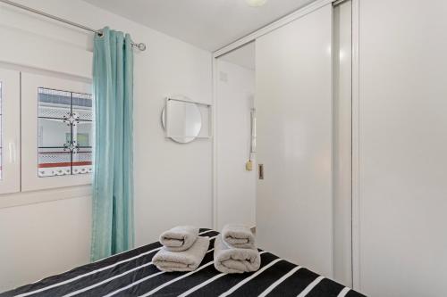 a bedroom with a bed with towels on it at Casa Paula - 21 in Arinaga