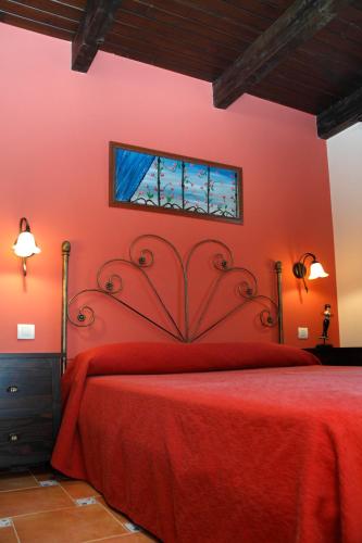 a red bedroom with a red bed and a window at Finca El Encinar in Pedro Muñoz
