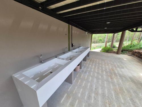 a large bathroom with a row of sinks on the wall at The Hilltop Erawan in Si Sawat
