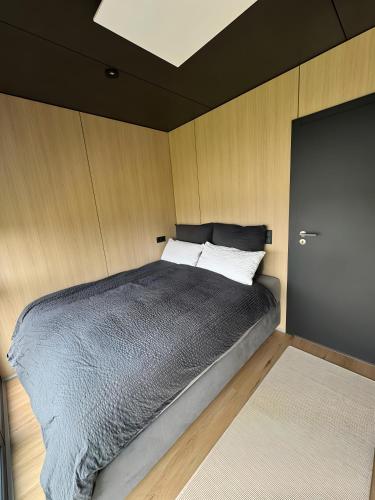una camera da letto con un grande letto e pareti in legno di Chalet Seewald - Tiny House a Seewald