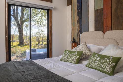 a bedroom with a bed and a large window at Lodge para parejas con jacuzzi hidromasaje in Panguipulli