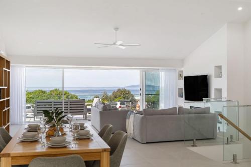 a living room with a table and a couch at Thalassa Views Ulladulla in Ulladulla